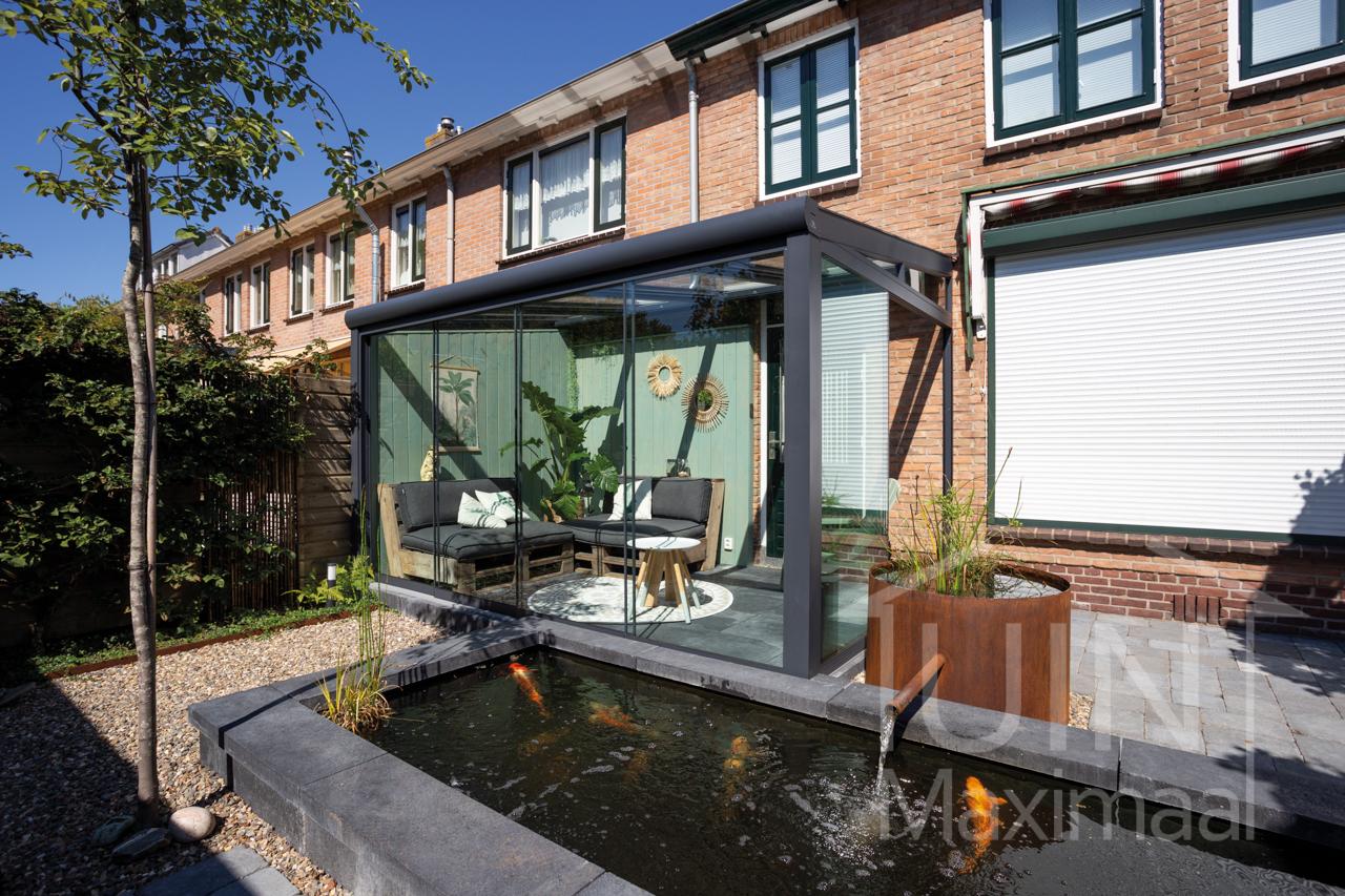 Terrasoverkapping in een kleine tuin met vijver