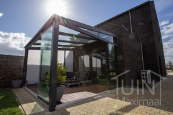 Moderne Gumax® Terrasoverkapping in mat antraciet van 4,06 x 4,0 meter met glazen dakplaten inclusief Gumax zonwering en Glazen schuifwanden en glazen spie